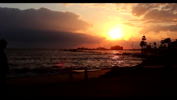 Silhouette delle persone anziane turista a piedi sulla spiaggia resort al tramonto arancione vista posteriore — Video Stock