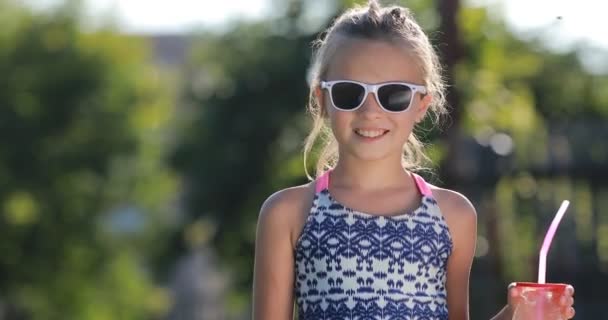 Χαμογελώντας Όμορφο Κοριτσάκι Χαριτωμένο Νήπιο Μαγιό Γυαλιά Ηλίου Πίνει Χυμό — Αρχείο Βίντεο