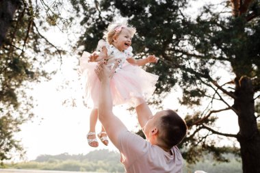 Baba doğaya bebek atar, kız gökyüzünde uçar. Babamın çocuklu portresi. Baba, küçük kızım dışarıda. Küçük kızıyla birlikte parkta yürüyen genç bir baba. Bahçede ya da ormanda aile tatili
