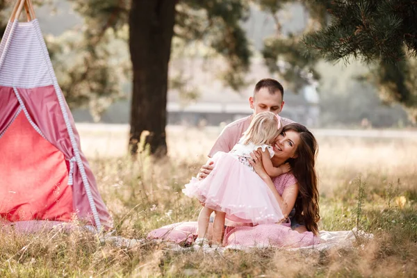 在公园里 爸爸和小女儿坐在摇晃的装饰旁边 一家人夏天都呆在户外 在一起玩得很开心 女孩穿着粉红色的衣服 — 图库照片