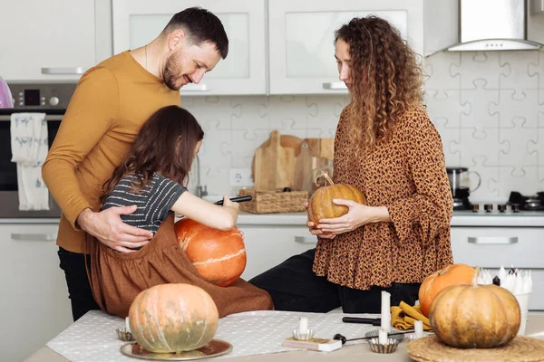 Família feliz mãe pai e filha criança se preparar para o Halloween decorar a casa com abóboras e fazer jack, rindo e brincando. foco seletivo — Fotografia de Stock