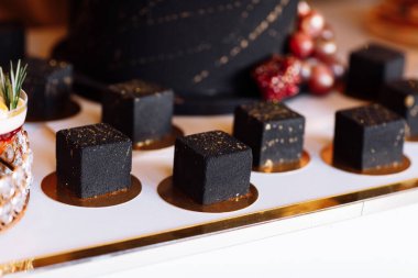 Koyu çikolatalı kremalı Fransız pastası. Altın madalyayla süslenmiş modern Avrupa tatlısı. seçici odak.