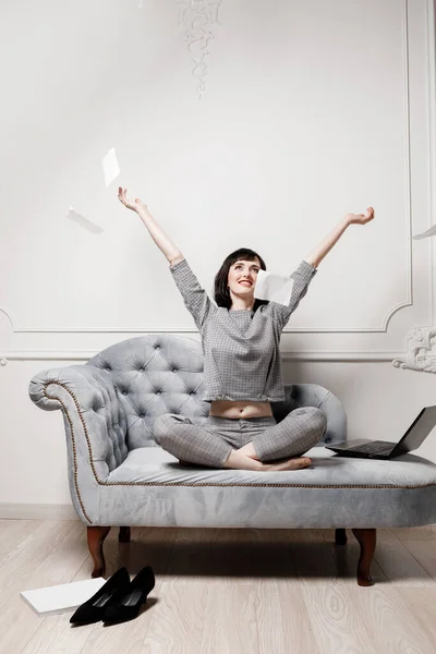 Beautiful businesswoman in gray suit is using laptop and scattering paper documents in a desire to take a break from work. High quality photo. mock up. selective focus. — Stock Photo, Image