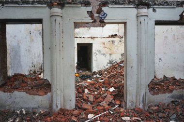 Hanoi Vietnam yakınlarında yıkılmış tuğlalar ve diğer taş yıkıntılarıyla dolu kısmen yıkılmış bir bina. Giriş kapısının üzerinde 32 numara sallanan klasik bir diş minesi tabelası..