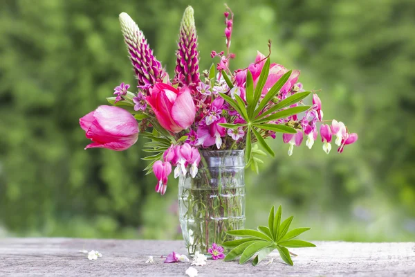 A bouquet of beautiful flowers of red on a green garden backgrou — Stock Photo, Image