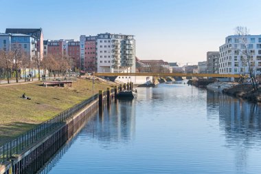 Berlin, Almanya - 1 Mart 2021: Berlin-Spandau nakliye cana üzerinde inşa halindeki Golda-Meir-Steg köprüsü ile Nordhafen limanında güneşlenme çimenliği