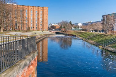 Berlin, Almanya - 1 Mart 2021: Banka merdivenli satıcı parkı, Nordhafen 'in ön bölümü (Panke' nin limana aktığı yer) ve Scharnhorst alt istasyon binasının listelenmiş tıkırtısı