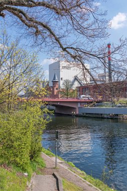 Berlin, Almanya - 20 Nisan 2021: Berlin-Spandau nakliye kanalı Foehrer köprüsü ve birleşik ısı ve elektrik santrali Moabit ile 1900 yılında inşa edilmiş tarihi liste binası 