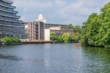 Berlin, Almanya - 3 Temmuz 2021: Yeni inşa edilmiş binaları ve Fraunhofer Telekomünikasyon Enstitüsü 'nün kulesiyle Spree the River Bank