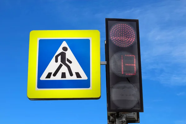 Yaya trafiği ışığı ve trafik ışığı, trafik ışıklarında kırmızı ışık, sinyal yasak. Bulanık mavi gökyüzünün arkaplanı.