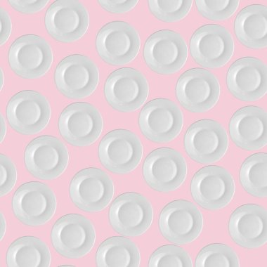 Açık pembe pastel arka planda beyaz plakalar, üst manzara, düz yatış. Kusursuz desen. 