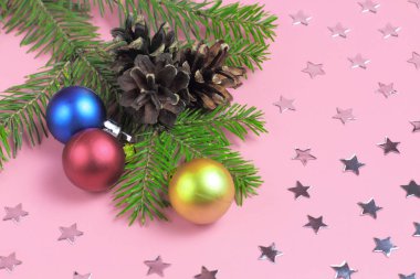Noel arkaplanı, kozalaklı köknar dalı ve pembe renkli Noel topları..