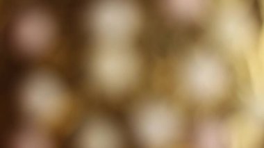 Noel çelenginin bulanık ışıkları, altın bir arka planda bokeh. Farklı renklerde parıldayan ışıkların, parlak ışık noktalarının şenlikli arka planı.