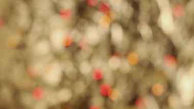 Noel çelenginin bulanık ışıkları, altın bir arka planda bokeh. Farklı renklerde parıldayan ışıkların şenlikli arka planı.