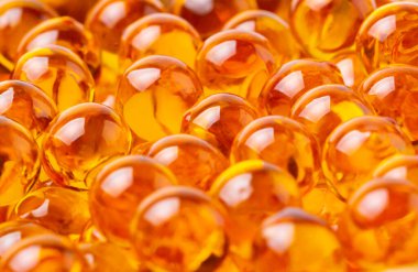 Arka planda balık yağı veya kril yağı bulunan kapsüller veya haplar