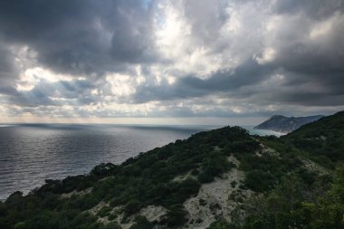 Akşam deniz manzarası, fırtınalı hava ve deniz manzarası üzerindeki kara bulutlar..