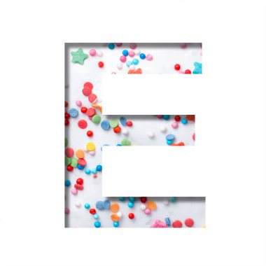 Tatlı jöleli yazı tipi. E harfi, arka plandaki beyaz tatlı jöleli kağıttan kesilmiş. Renkli serpiştirilmiş. Dekoratif tatil ya da doğum günü yazı tipi seti.