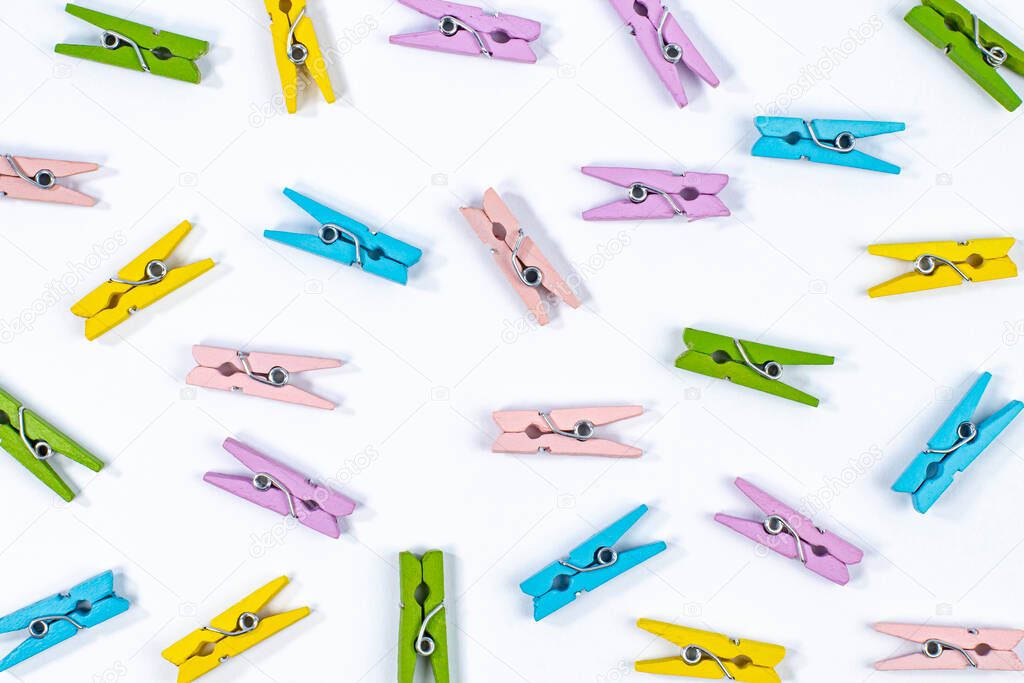 Pattern of colored decorative clothespins on white, top view.
