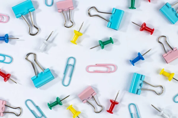 Arkaplan olarak beyaz üzerine renkli ataç ve raptiye deseni