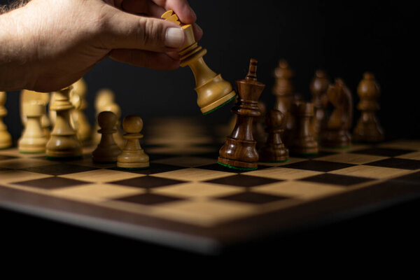 шахматная игра, шахматная доска с фигурами и человеческой рукой, концепция победы или успеха игры или бизнеса.
