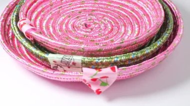 Beyaz bir arka planda döner tablada ipten yapılmış el yapımı kumaş dekoratif plakalar.