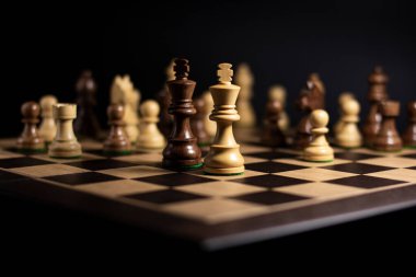 Karanlık arka planda aralıklı figürlere sahip satranç tahtası, akıllı görev veya iş stratejisi kavramı