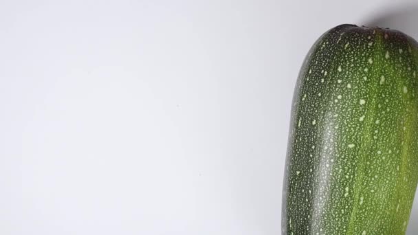男子的手在白底特写的基础上滚动着不同品种的新鲜的南瓜 — 图库视频影像