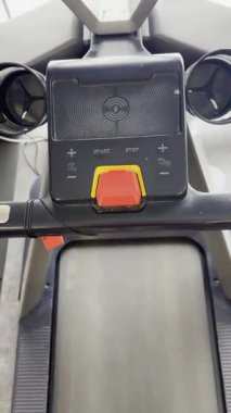 Modern bir koşu bandı üzerinde koşan bacakların dikey POV (bakış açısı) çekimi. Video, profesyonel bir spor salonundaki egzersiz ve fitness eğitiminin hareketini kaydediyor. Sağlık, spor ve kardiyo ile ilgili içerik için ideal.