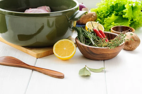 RAW kaninkött med grönsaker och örter i runda keramiska potten på vitt trä bord yta — Stockfoto