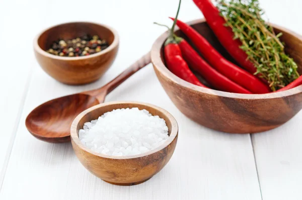 Sal, pimienta, chile y tomillo en cuencos sobre mesa de madera rústica blanca — Foto de Stock