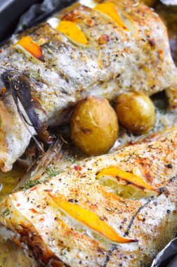 Limon dilimleri ve küçük patates pişmiş mezgit balığı