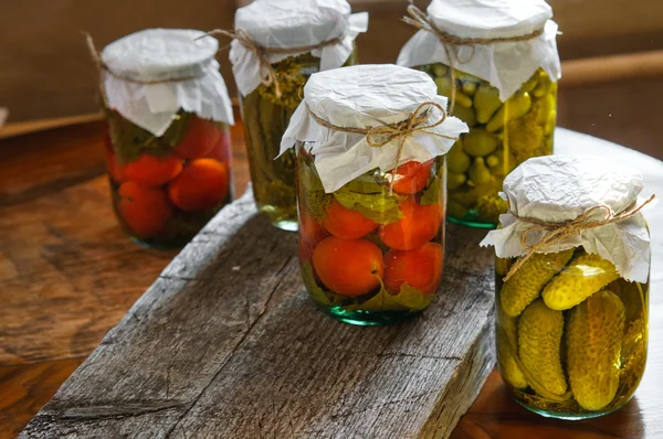 Glass jars of colorful pickled vegetables in rustic style close-up — Stock Photo, Image