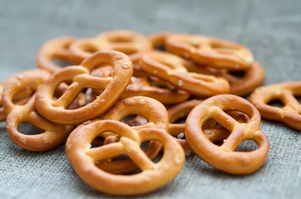 Heap of fresh Wheat salt pretzels on hessian linen fabric cloth — Stock Photo, Image