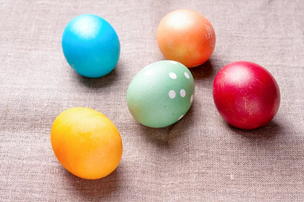 Group of colorful Easter eggs lying on linen fabric cloth close up — Stock Photo, Image