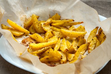 Kavrulmuş patates patates dilimleri ile fırın kağıt üzerinde biberiye makroyu kapatın