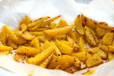 Kavrulmuş patates patates dilimleri ile fırın kağıt üzerinde biberiye makroyu kapatın