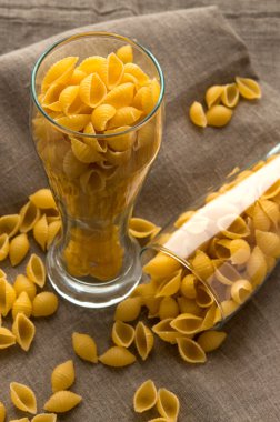 Sanat natürmort kabuk makarna makarna kendir keten kumaş bez arka plan üzerinde cam