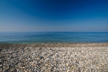 Deniz çakıl shore veya plaj ve derin mavi gökyüzü