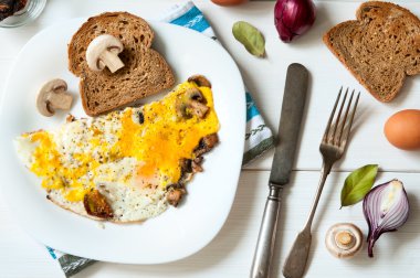 Doyurucu kahvaltı: tabak kızarmış yumurta ve ekmek beyaz masa yüzeyi, en iyi düz görünüm ile mantar
