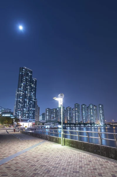 Geceleri Hong Kong 'da yüksek binalar ve limanlar.