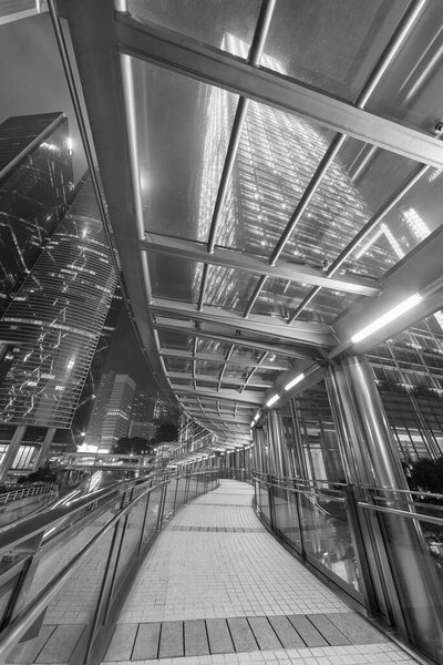 пешеходная дорожка и небоскреб в Гонконге ночью
