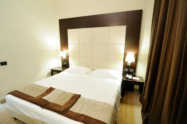 Ένα Κρεβάτι Ένα Δωμάτιο Ξενοδοχείου Δύο Κομοδίνα Λάμπες Ψηλό Κεφαλάρι — Φωτογραφία Αρχείου