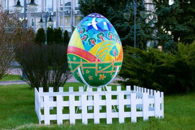 Beyaz çitlerle çevrili büyük bir Paskalya yumurtası boyadım. Şenlik gösterisi. Ukrayna, Vinnytsia - 28 Nisan 2021.