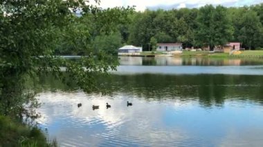 Gölde bir yaz günü, bulutlar dalgalanan suyu yansıtıyor. 