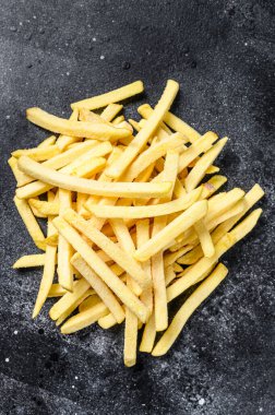 Frozen French fries, organic vegetables. Black background. Top view. clipart