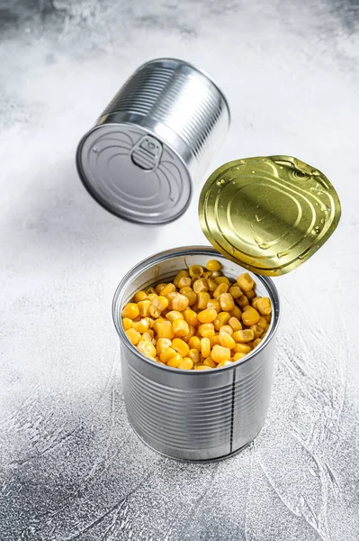 Grains of sweet canned corn in a can. White background. Top view.