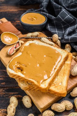 Kahvaltıda fıstık ezmeli çıtır tost. Karanlık ahşap arka plan. Üst görünüm.