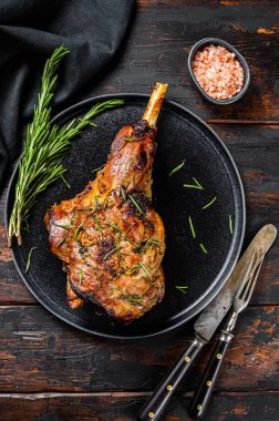Kızarmış keçi budu. Çiftlik eti. Karanlık ahşap arka plan. Üst görünüm.