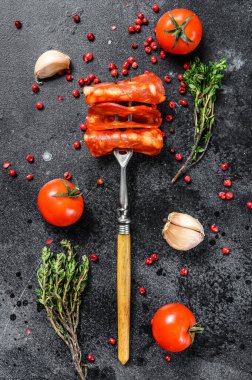 Chorizo sosisi ince kesilmiş. Baharatlı İspanyol salamı, kırmızı biber, biber. Baharatlı yemek. Siyah arka plan. Üst görünüm.