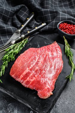 Düz demir biftek. Çiğ mermer et, siyah Angus. Siyah arka plan. Üst görünüm.
